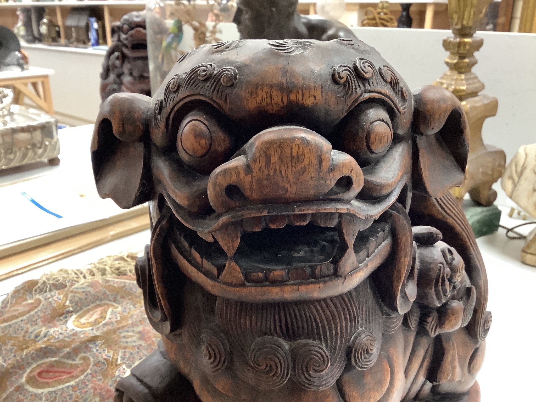 A pair of Chinese carved hardwood Buddhist lions, width 26cm height 37cm